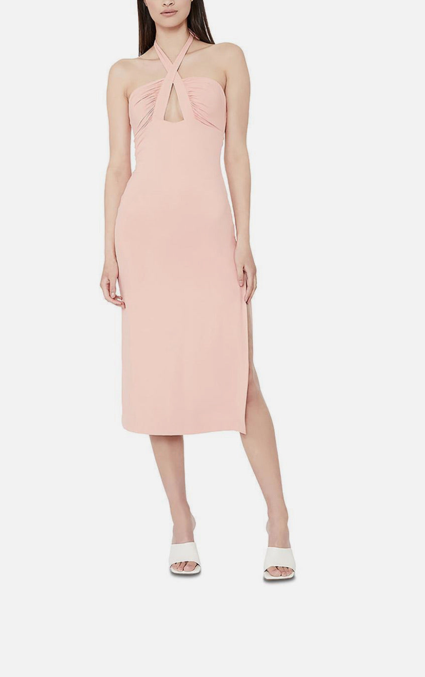 Woman wearing a pink halter neck dress on a white background