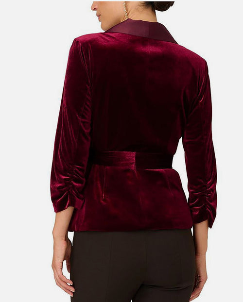 Burgundy velvet jacket worn by a person on a white background