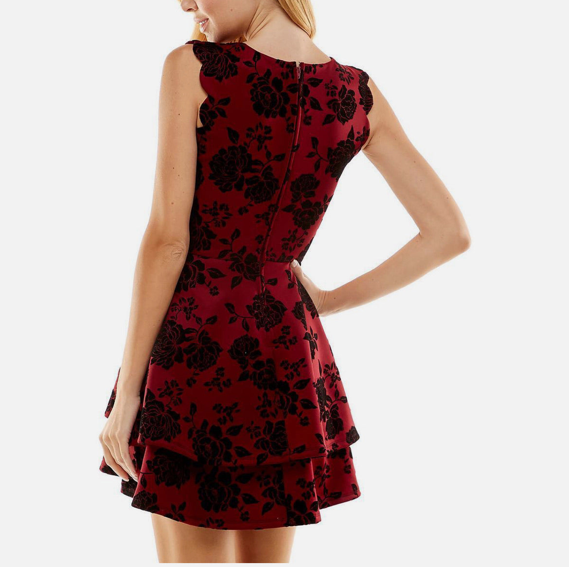 Red dress with black floral pattern worn by a person on a white background