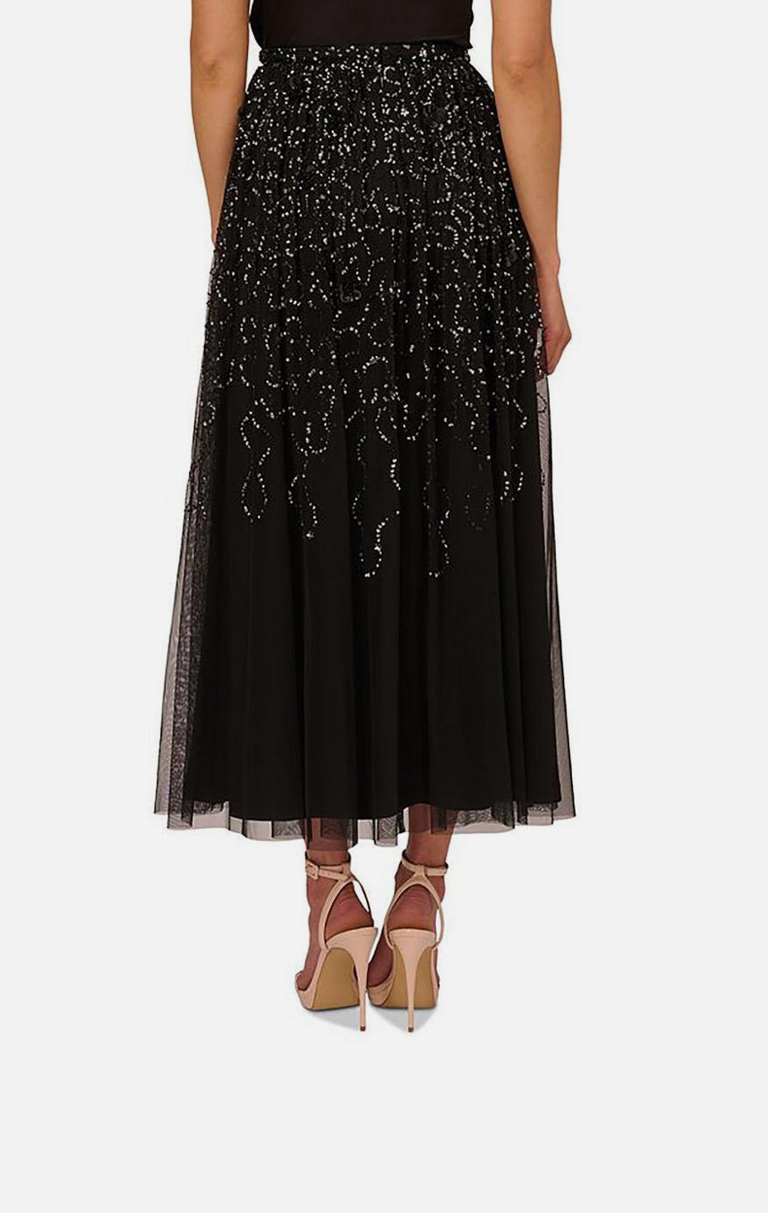 Black embroidered skirt worn by a person on a white background