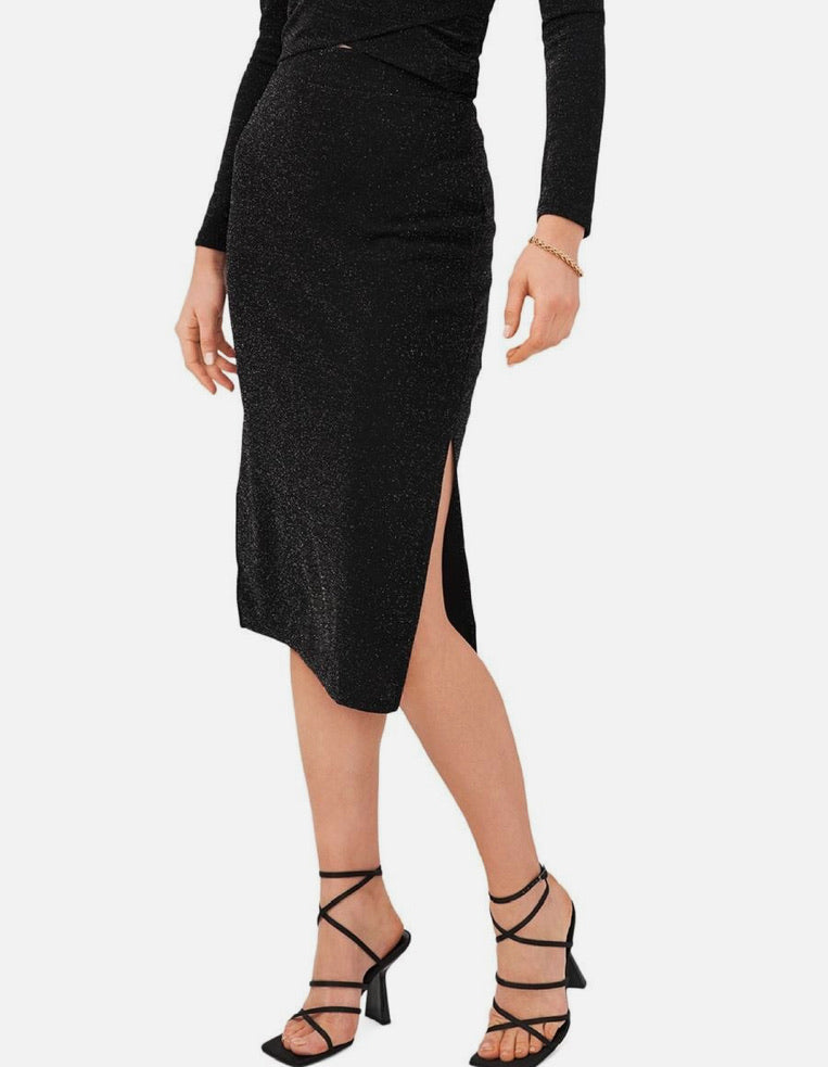 Person wearing a black dress with a slit on a white background