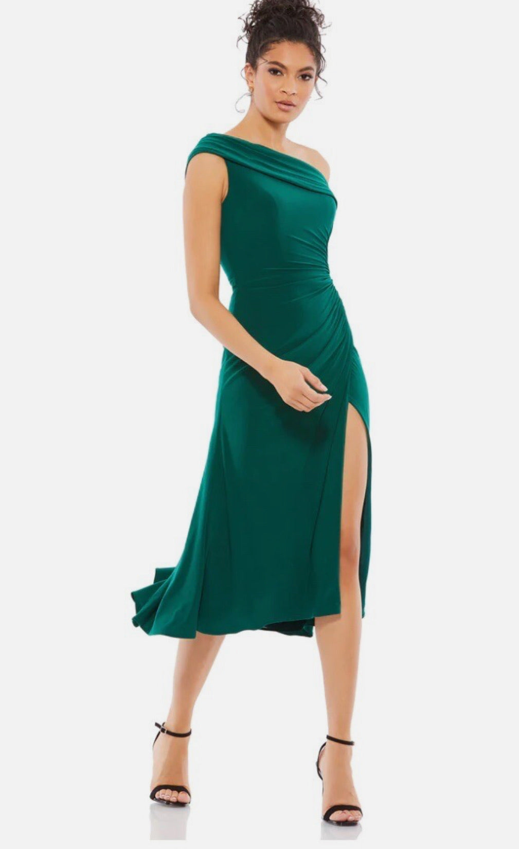 Woman wearing a green one-shoulder dress with a slit on a white background