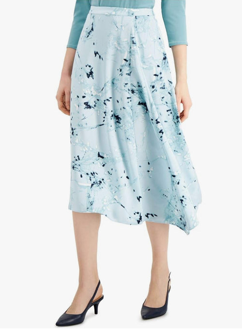 Woman wearing a light blue skirt with black abstract pattern on a white background