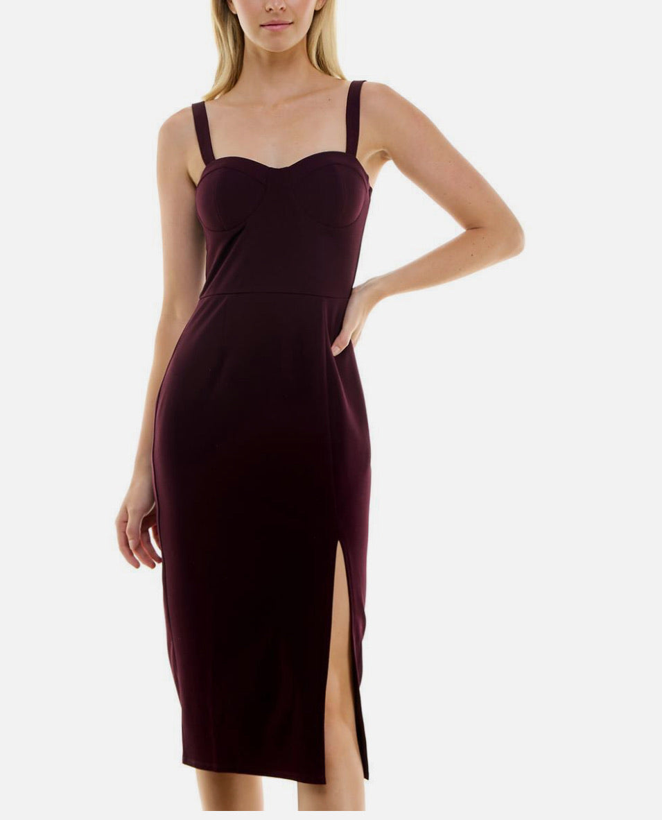 Woman wearing a burgundy dress with a slit on a white background