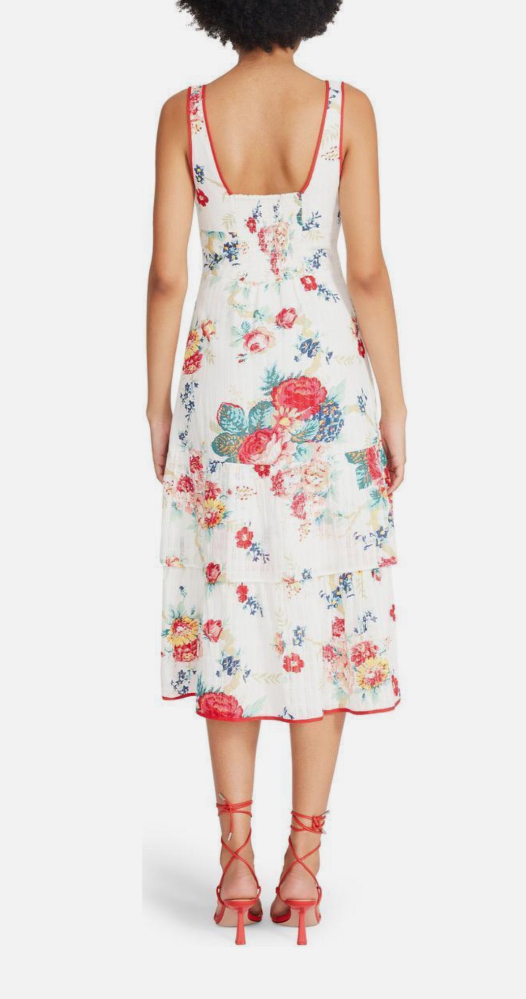 Woman wearing a floral dress with red straps on a white background